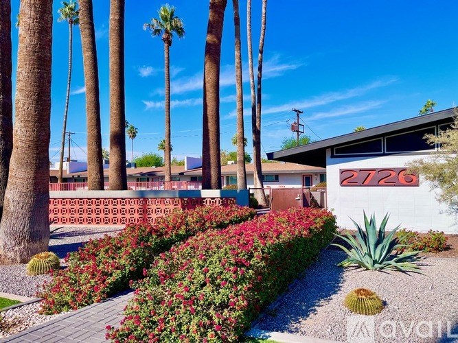 A house numbered 2726 is surrounded by a garden and palm trees.
