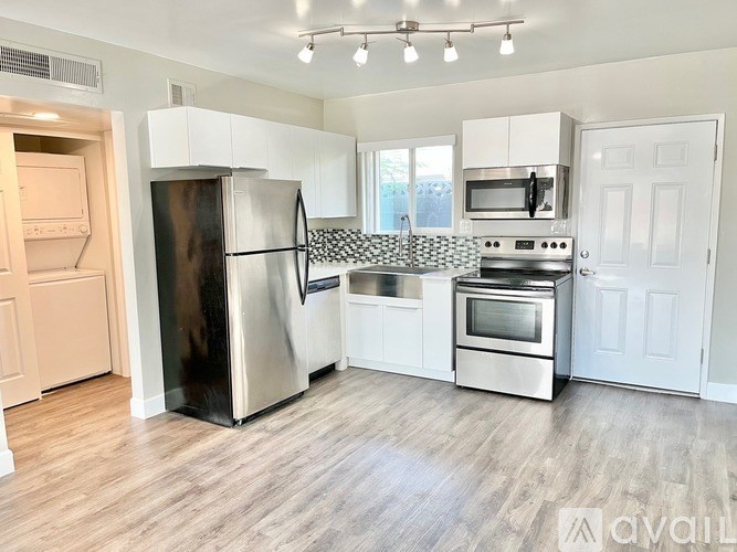 A kitchen with a stainless steel refrigerator, oven, and microwave.