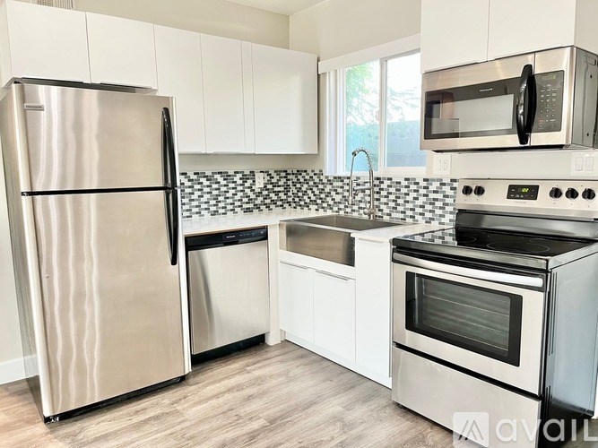 A kitchen with a stainless steel refrigerator, microwave, oven, and dishwasher.