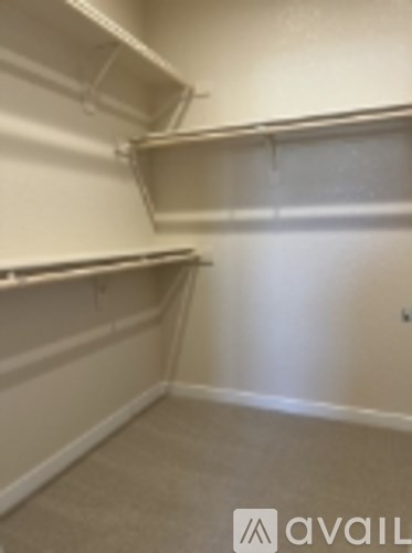 Empty room with shelves and a wall outlet.