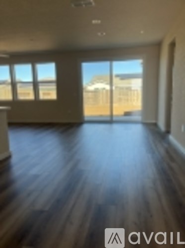 A room with wooden floors and a view of a building outside the window.