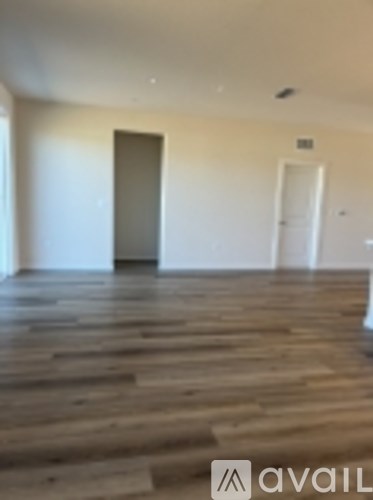 A room with wooden floors and two doors.