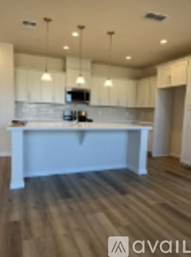 A kitchen with a white island and wooden floors.