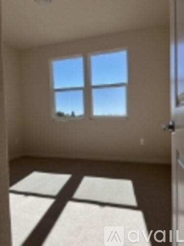 A room with a large window and a white rug on the floor.