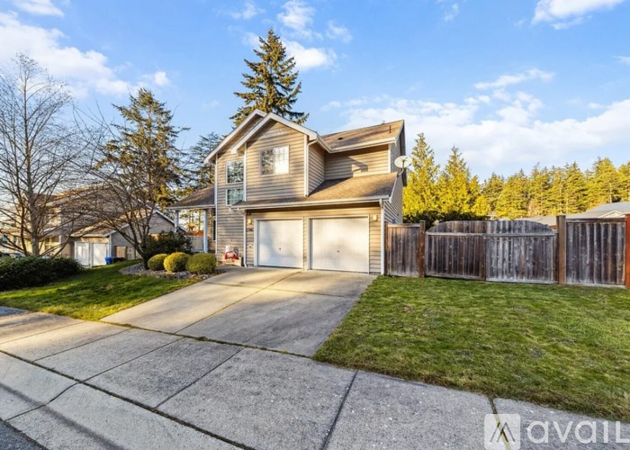 A house with a garage and a driveway in front of it.