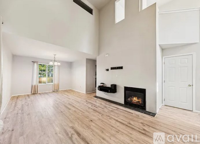 A spacious living room with a fireplace and wooden flooring.