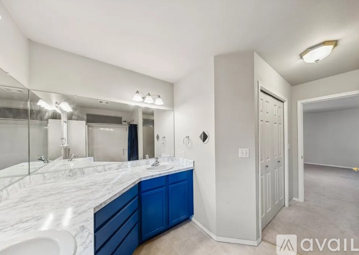 A bathroom with a marble countertop and blue cabinets.