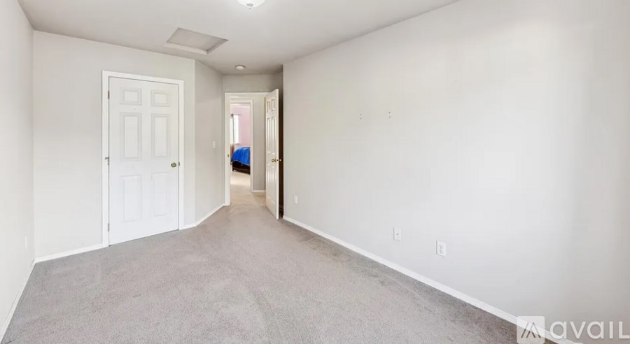 A spacious empty room with a door and a window.