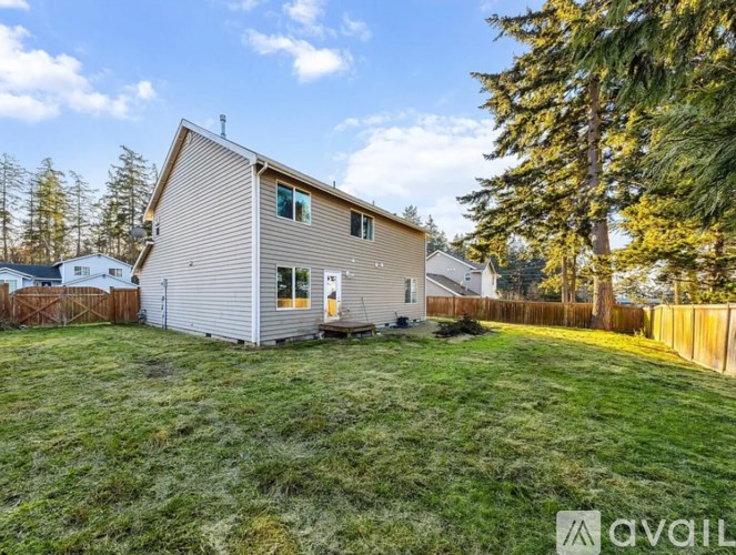A house with a fence and trees in the background.