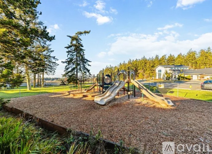 A playground with a slide and a brown surface.