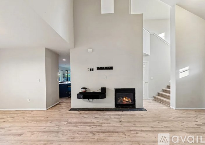 A modern living room with a fireplace and wooden flooring.