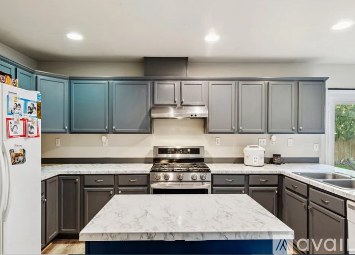 A kitchen with a white fridge and a marble counter top.