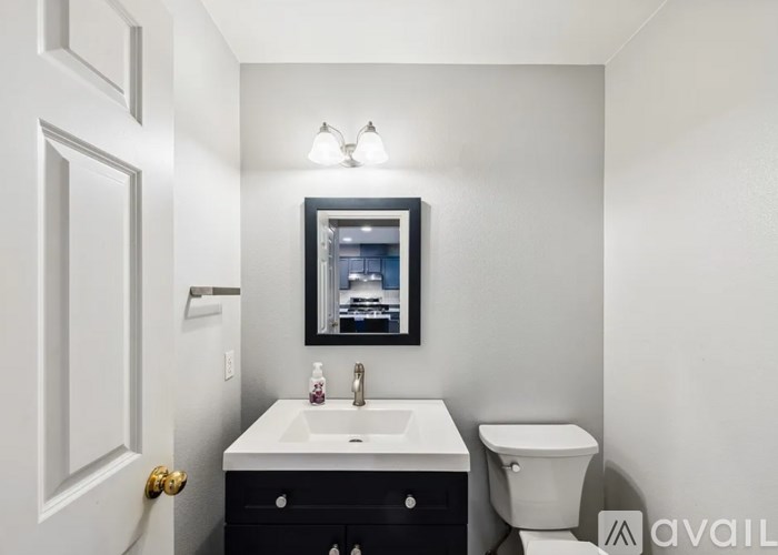 A bathroom with a sink, toilet, and mirror.