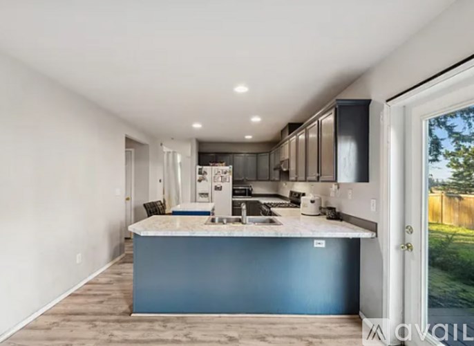 A kitchen with a blue island and wooden floors.