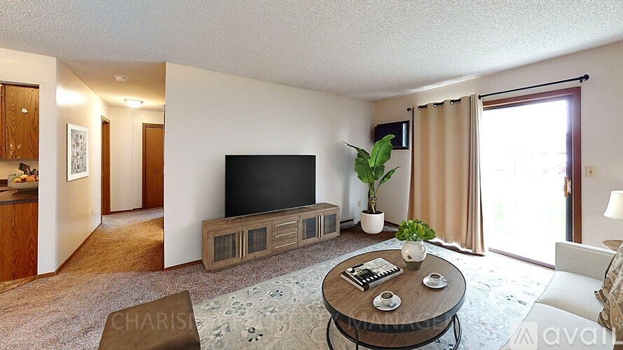 A living room with a flat screen TV and a coffee table.