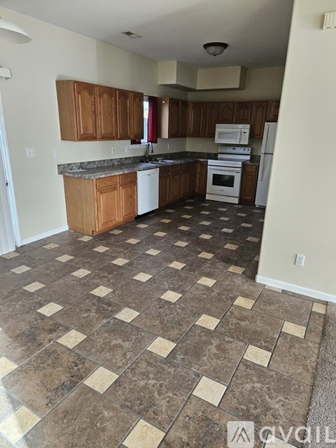 A kitchen with brown cabinets and a checkered floor.
