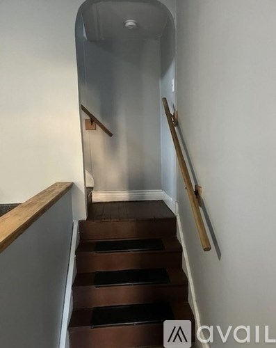 A staircase with a wooden handrail and steps.