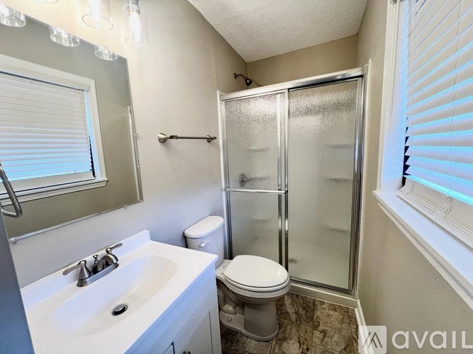 A bathroom with a toilet, sink, and shower.