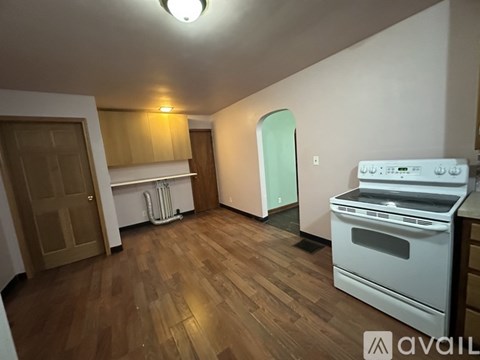 A kitchen with a white oven and wooden floors.