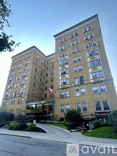 A tall building with a flag on the top floor.