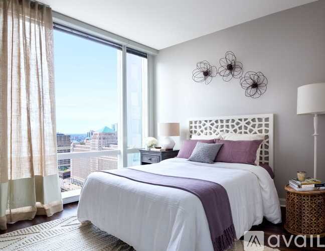 A bedroom with a large bed and a view of the city.