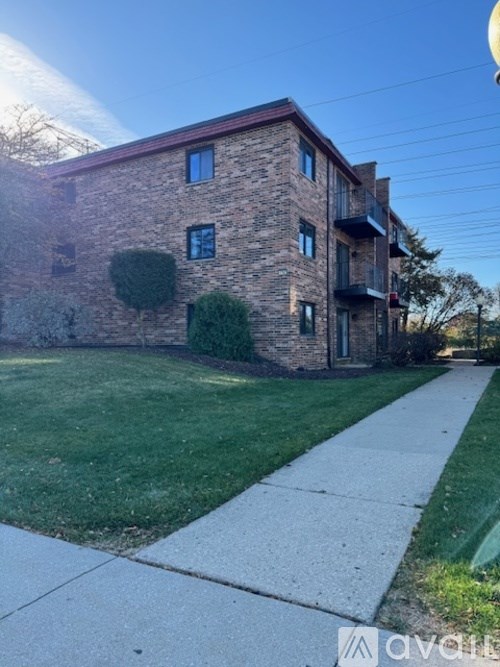A brick building with a green lawn in front.