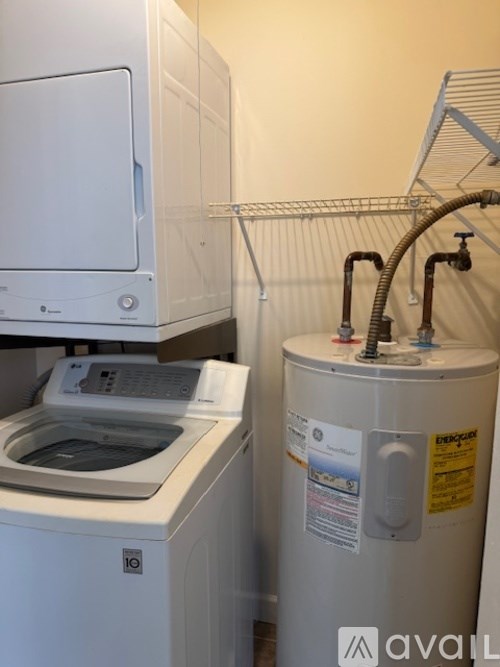 A white dishwasher is next to a water heater.