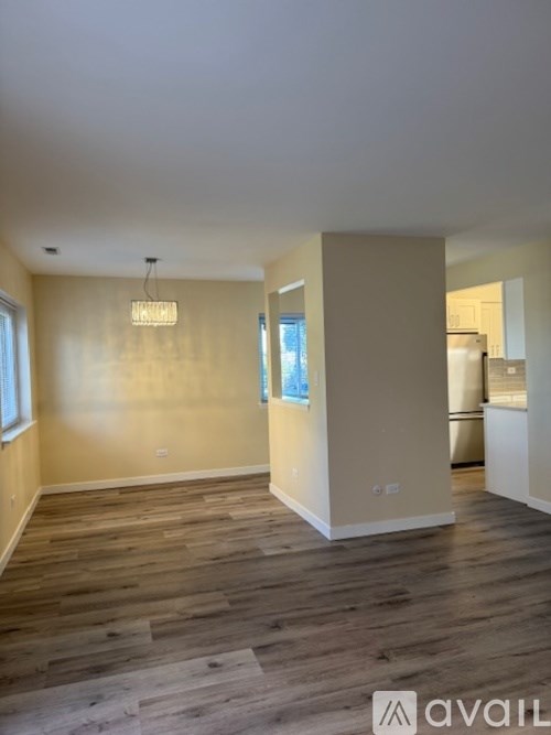 A room with wooden flooring and a hanging light fixture.
