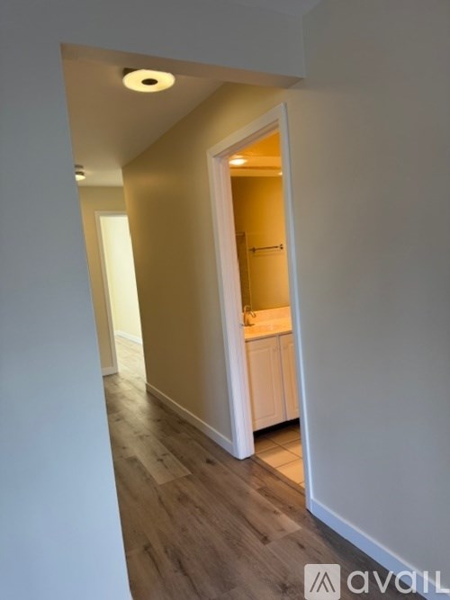 A hallway with a doorway leading to a kitchen.