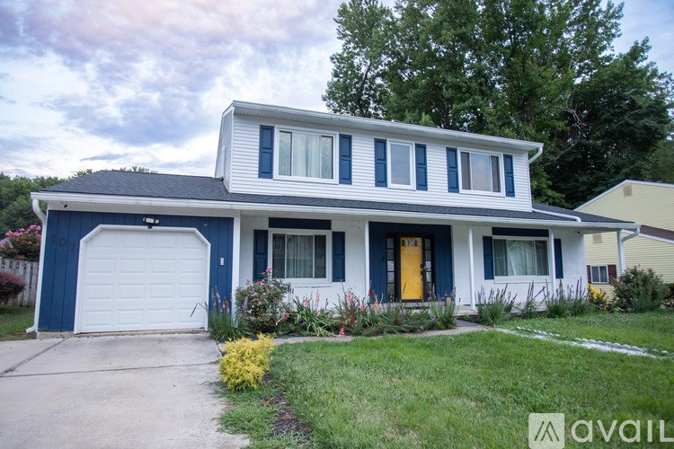 A two-story house with a blue garage door and a yellow front door.