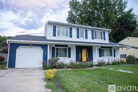 A two-story house with a blue garage door and a yellow front door.