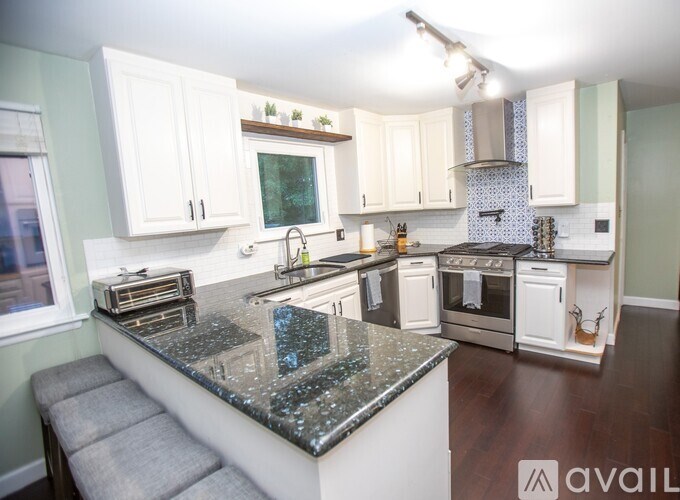 A kitchen with granite countertops and white cabinets.
