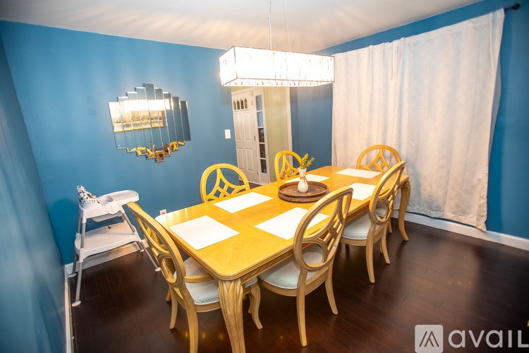 A dining room with a long table and chairs.