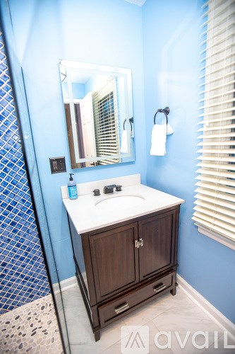 A bathroom with a blue wall and a white sink.