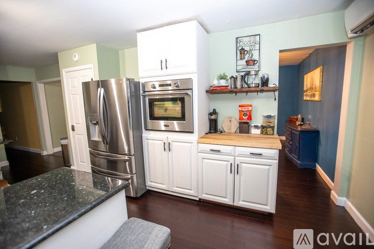 A kitchen with a refrigerator, oven, and microwave.