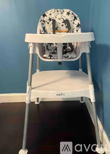 A white baby walker with a black and white patterned seat cover.