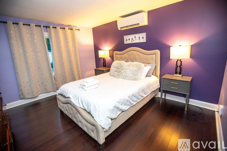 A bedroom with a bed, nightstand, and two lamps.