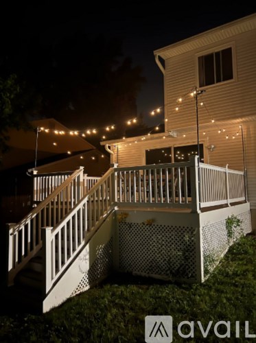 A house with a lit up front porch at night.