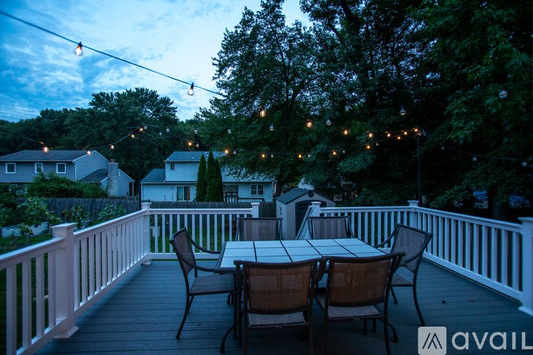 A deck with a table and chairs is set up for an evening of outdoor dining.
