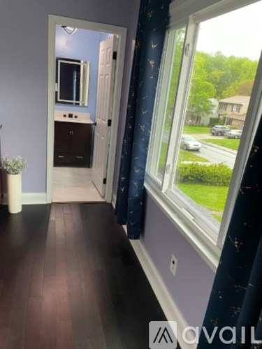 A room with a wooden floor and a window showing a street view.