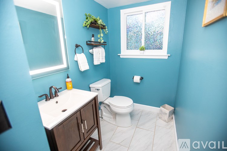A bathroom with blue walls and a white toilet.