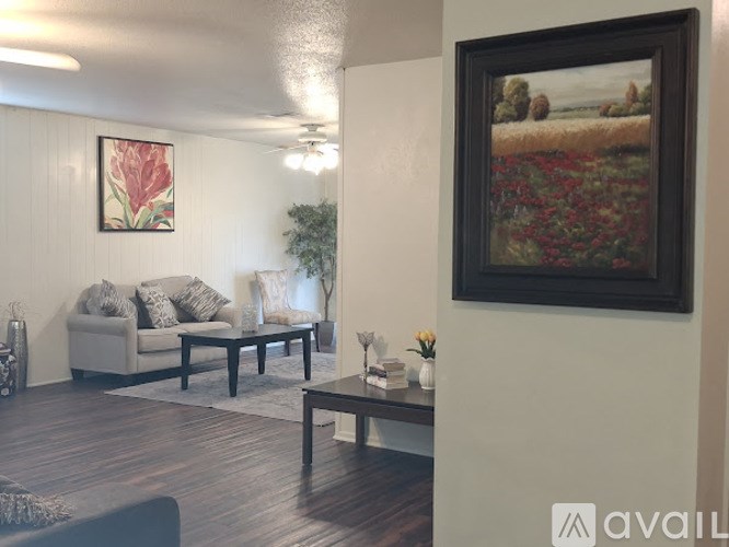 A living room with a couch, coffee table, and a painting on the wall.