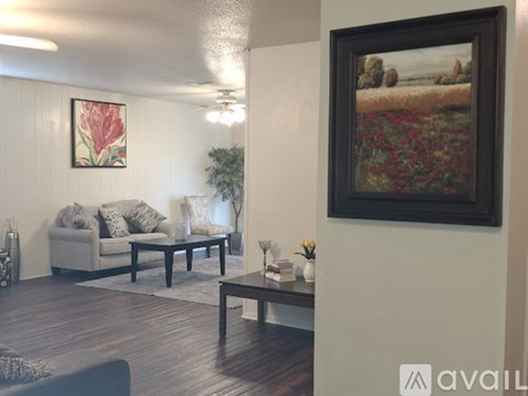 A living room with a couch, coffee table, and a painting on the wall.