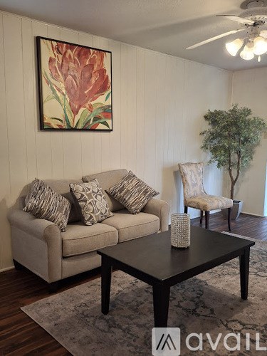 A living room with a couch, a coffee table, and a painting on the wall.