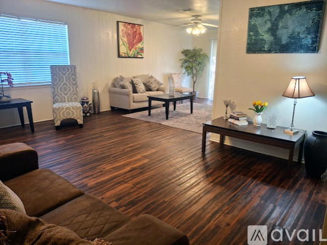 A living room with a brown couch and a wooden floor.