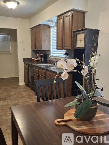 A kitchen with wooden cabinets and a brown table.