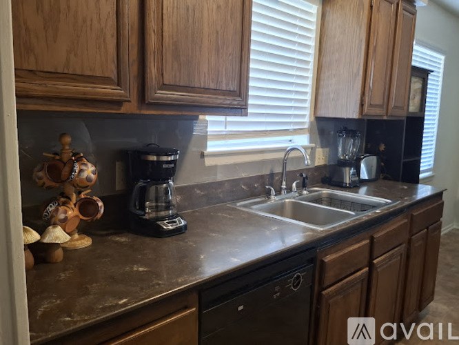 A kitchen with wooden cabinets and a black coffee maker.