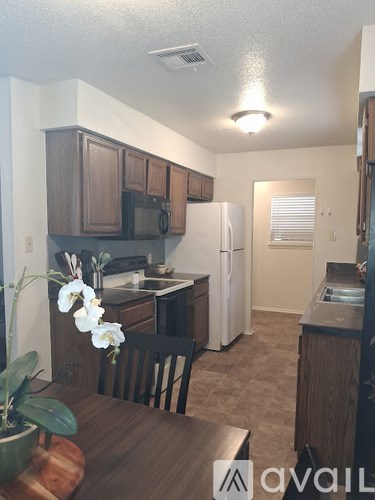 A kitchen with brown cabinets and a white refrigerator.