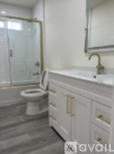 A white bathroom with a toilet, sink and mirror.
