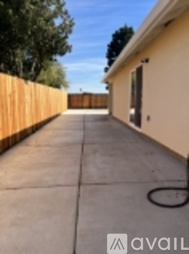 A long concrete walkway leads to a tan building.